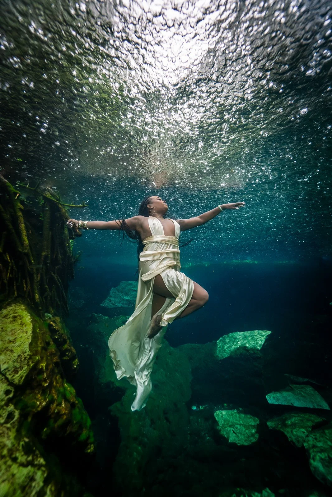 An African American woman posing for a cenote photoshoot on a rainy day