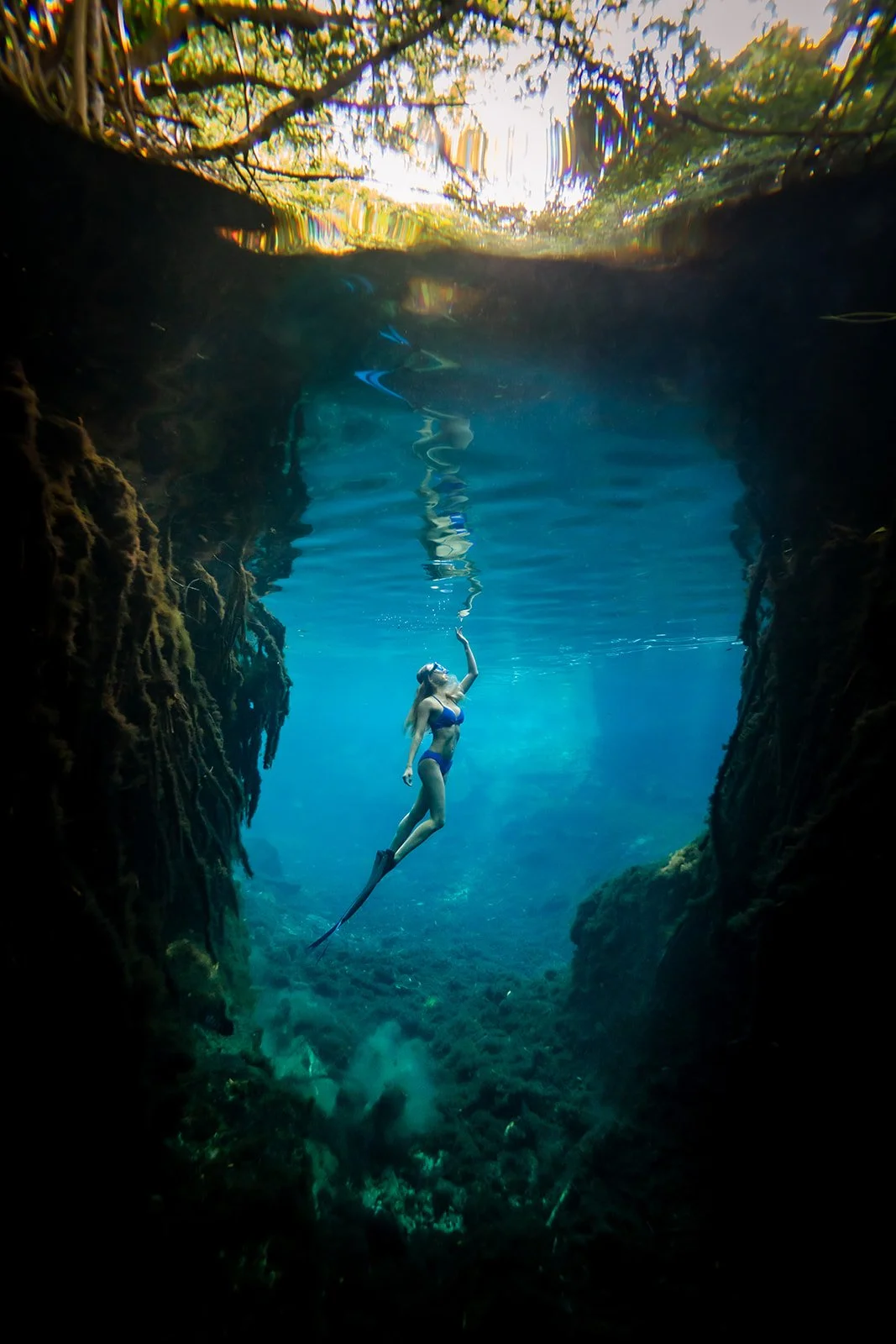 A woman posing in an underwater photoshoot in a cenote in Mexico