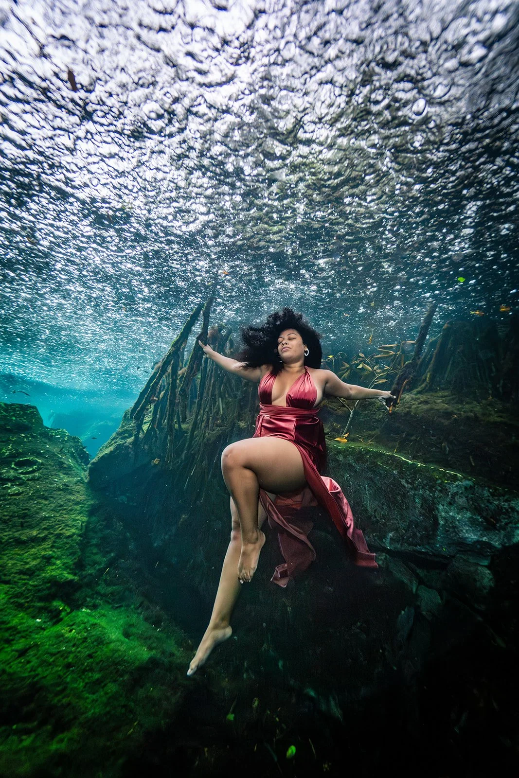 An African American woman posing for cenote photoshoot in Mexico