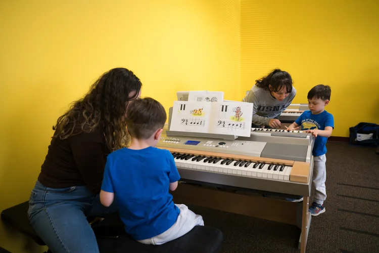 Parents and children learning keyboard skills together at Olenka School of Music