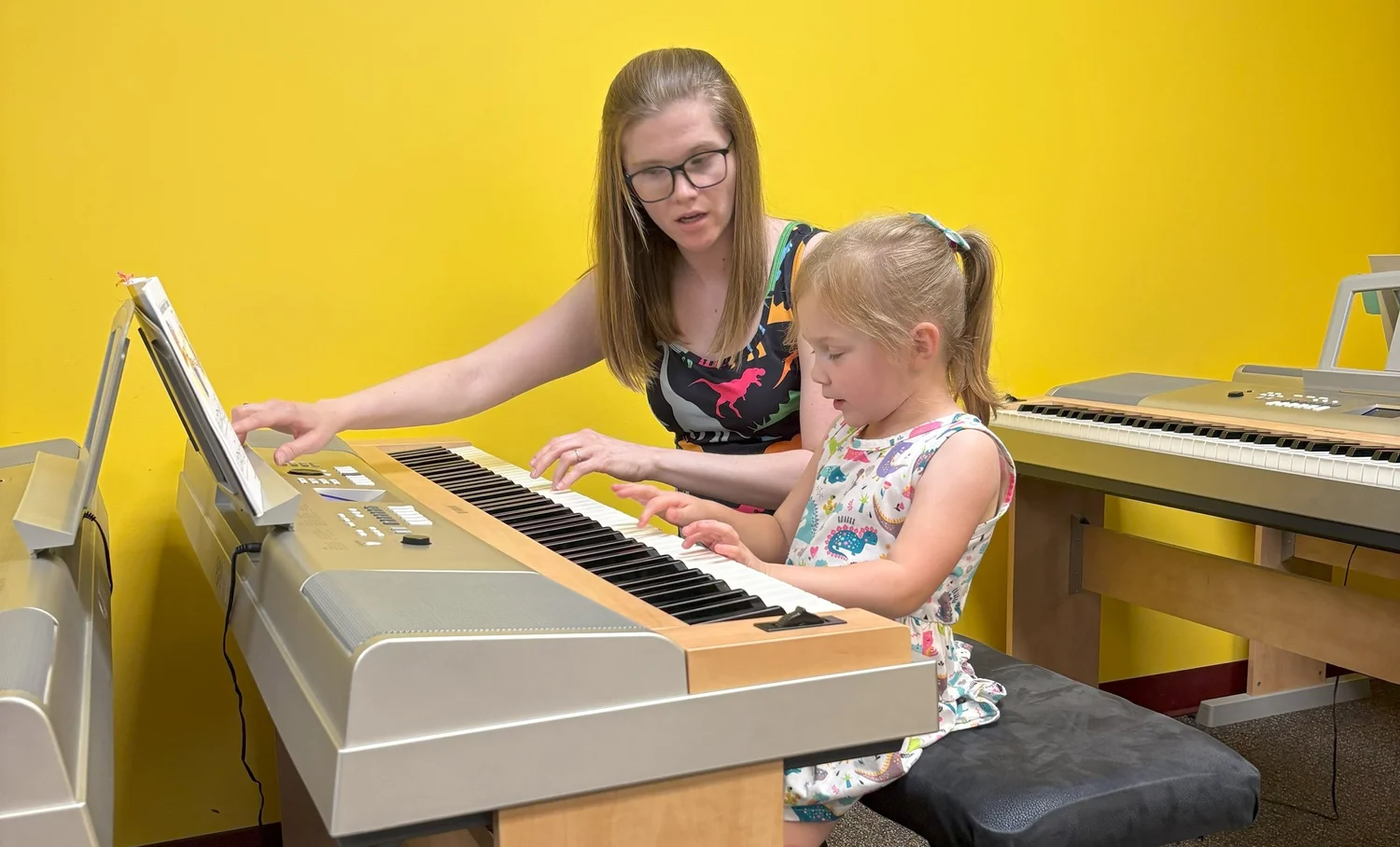 Teacher guiding a young student during a keyboard class at Olenka School of Music