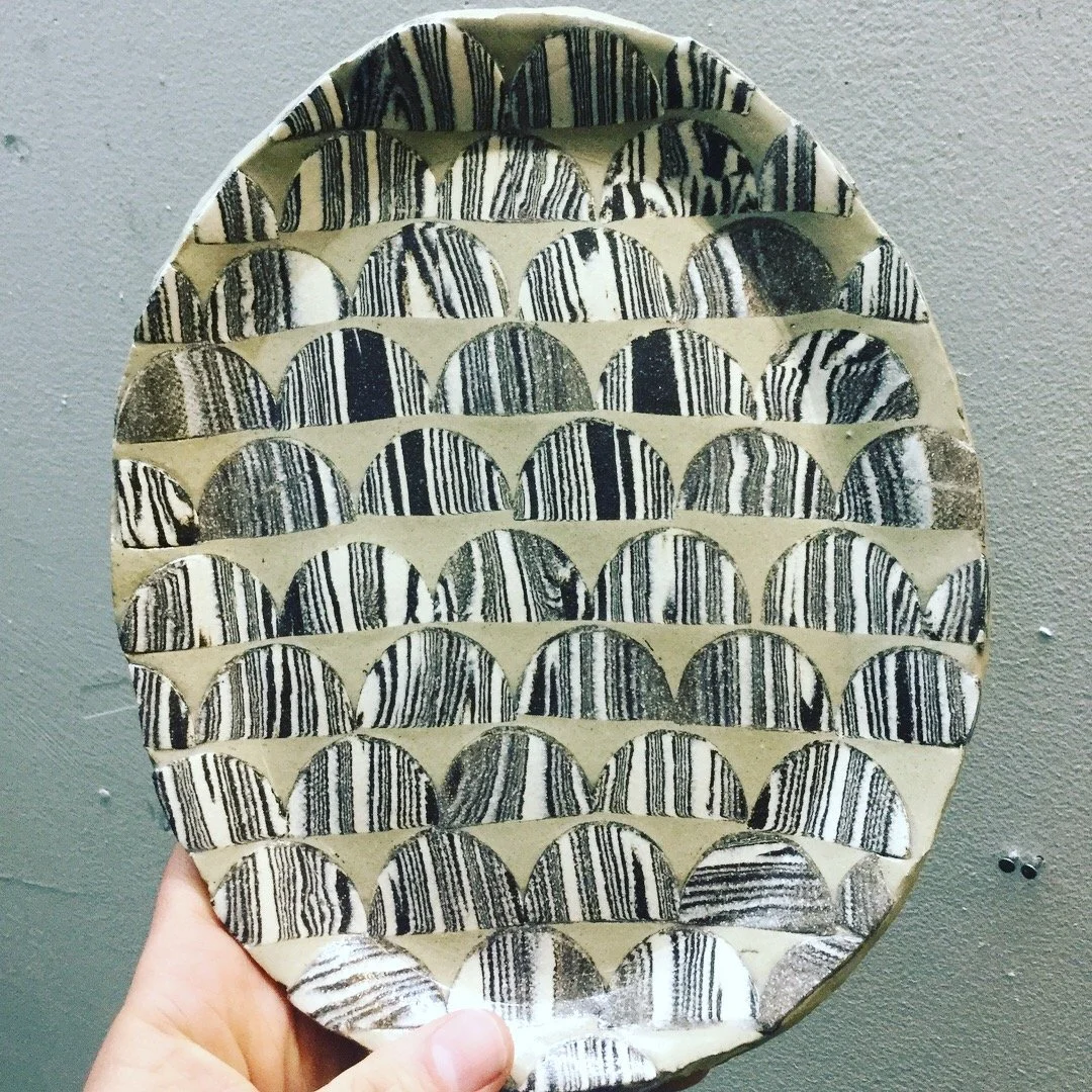 A decorative egg-shaped ceramic platter with black and white zebra stripe patterns.