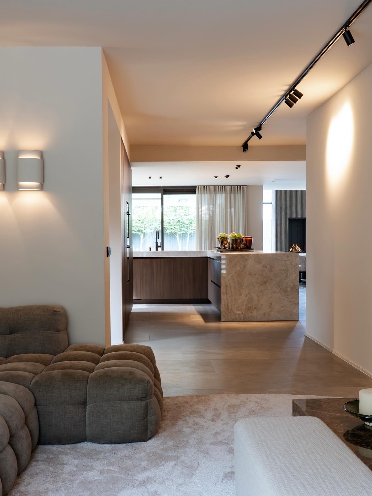 | DOORKIJK

Een doorkijk van de woonkamer, door het hart van de woning &ndash; de keuken &ndash; richting de eetkamer. 

Drie zones, elk met hun eigen functie, maar verbonden door een rustig lijnenspel en verfijnde materialen. 

De combinatie van ste