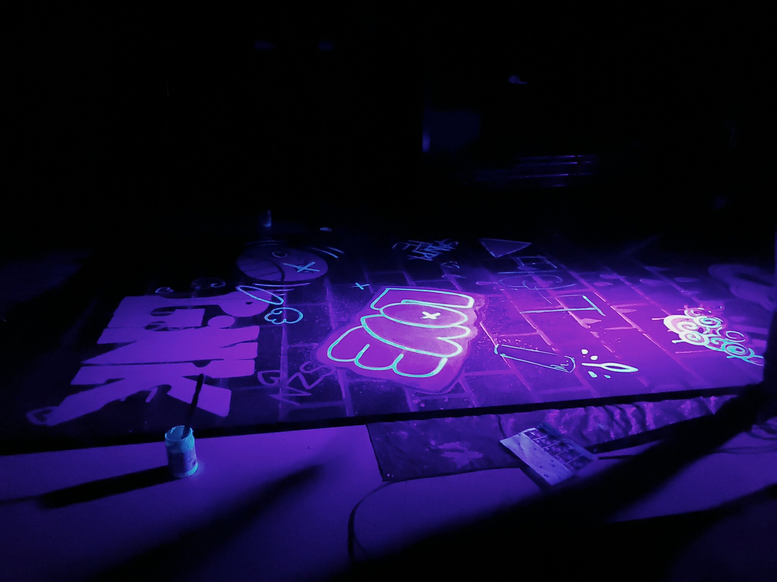 A black light view of a wall for RENT! at Village KIDSTAGE in 2019. Scenic Designed by Rebecca Strom.
Using Wildfire paint, we added UV reactive graffiti on top of painted brick and non-reactive graffiti.