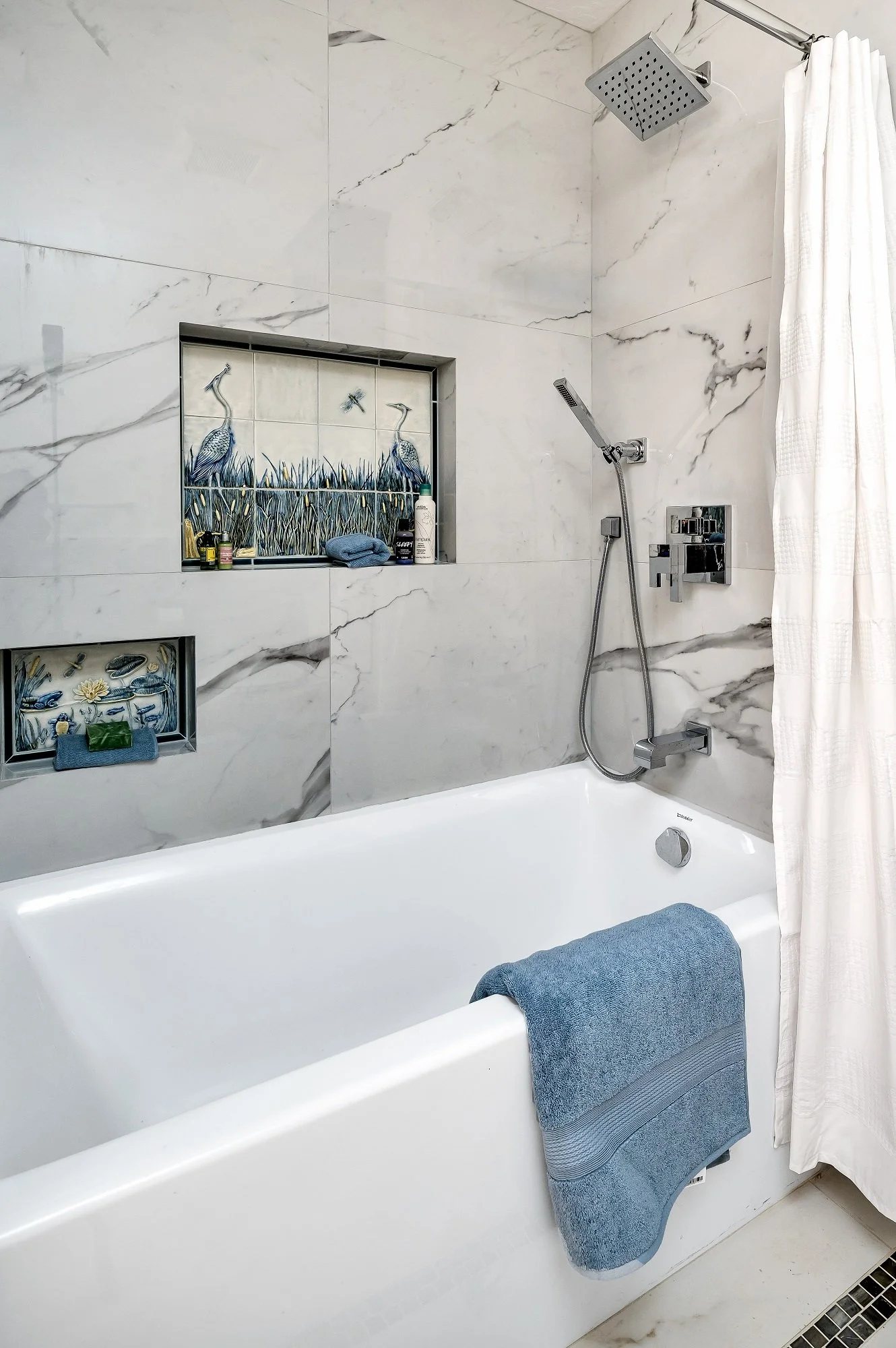 Tub and shower detail from a Santa Cruz condo remodel with large-format tile and integrated storage niches.