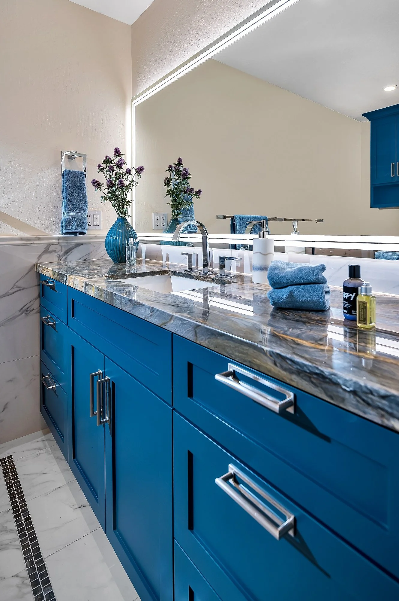 Secondary bathroom vanity in this Santa Cruz condo remodel featuring bold blue cabinetry paired with stone countertops and clean, modern hardware.