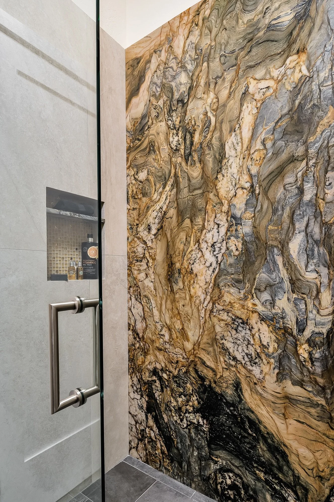 Stone slab shower entry detail from a Santa Cruz condo remodel with streamlined hardware and precise slab alignment.