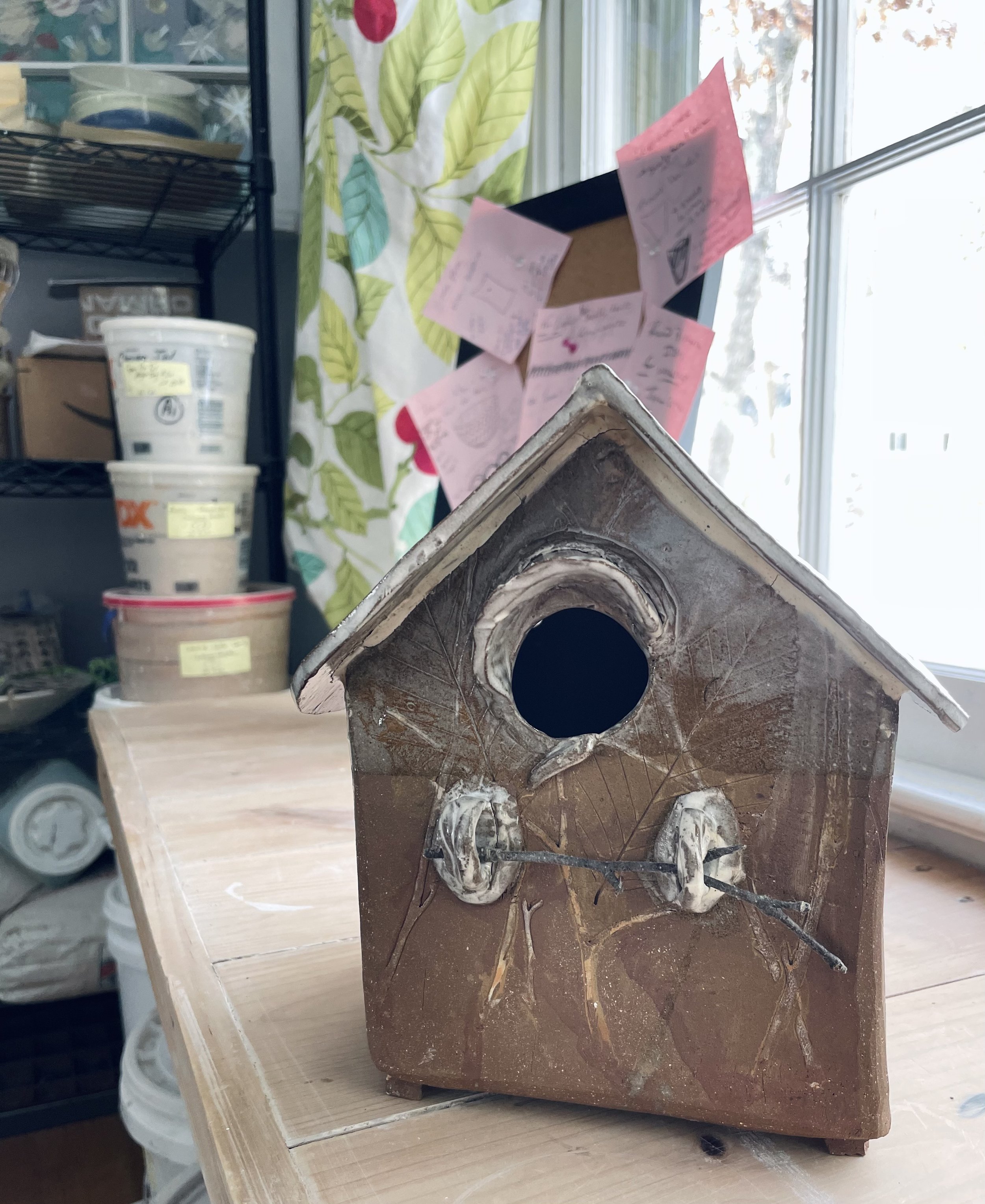 A free standing decorative birdhouse with birch tree inspired patterns on the clay walls.