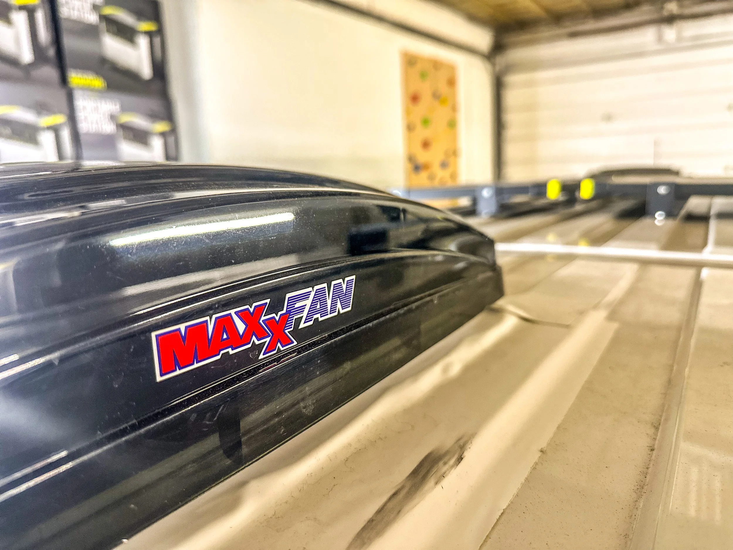 Close-up of a MAXxFan roof vent on a trailer, with the interior visible on the right side.