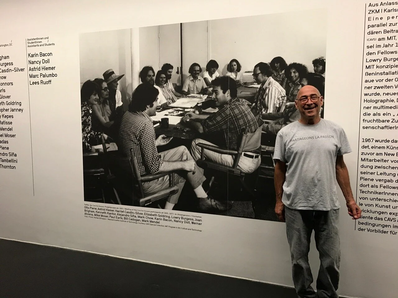 Image on wall shows CAVS-MIT artists who worked on Centerbeam in 1977Pictured: Otto Piene, Astrid Hiemer, Harriet Casdin-Silver, Elizabeth Goldring, Lowry Burgess, Joan Brigham, Kenneth Kantor, Alejandro Siña, Mark Chow, Karin Bacon, Nancy Doll, Wer…