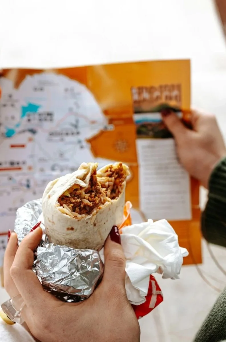 eating an al pastor burrito while looking at a map
