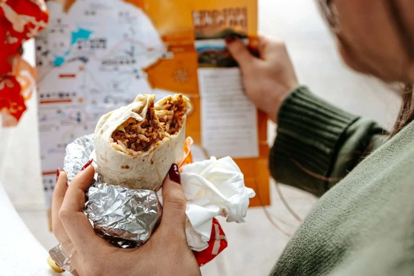 eating an al pastor burrito while looking at a map
