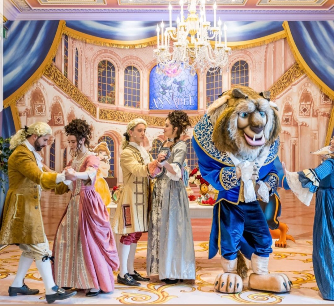Dance scene with performers in 18th-century costumes and a character in a Beast costume from Beauty and the Beast.