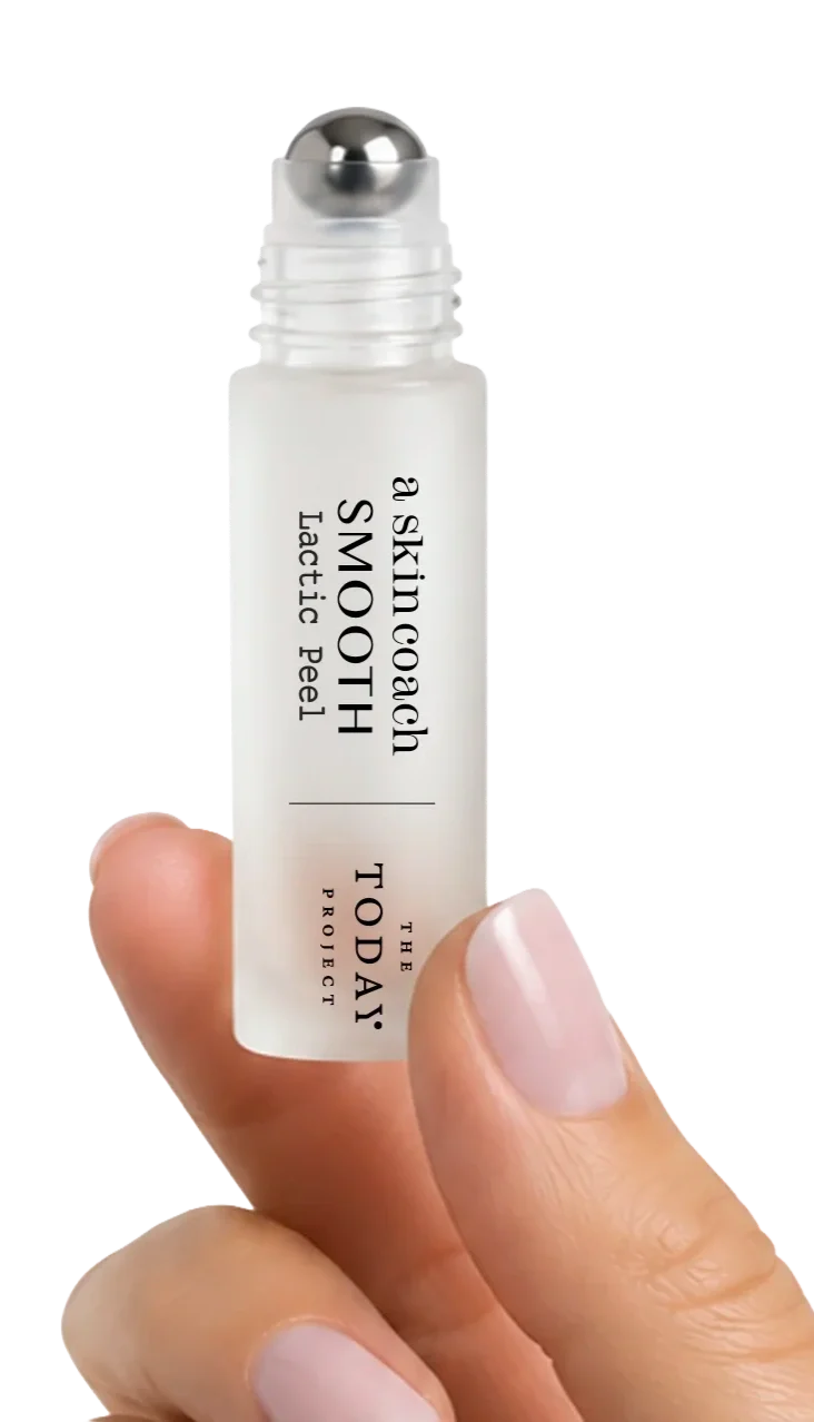 A hand holding a small white roller ball applicator with a white label that reads "a Skin coach SMOOTH tactical peel" and "THE TODAY PROJECT".