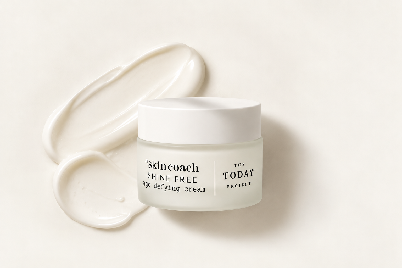 A jar of Skin Coach age defying cream with a smear of the cream nearby on a white background.
