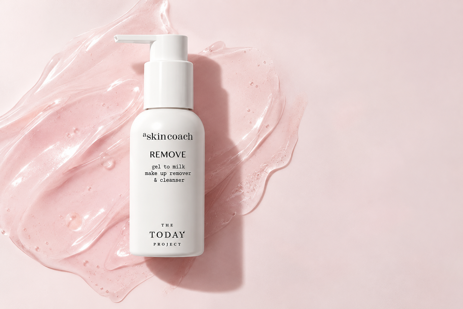 A white bottle of Skinceach REMOVE gel to milk makeup remover and cleanser on a pink background with a pink gel and water splash around it.