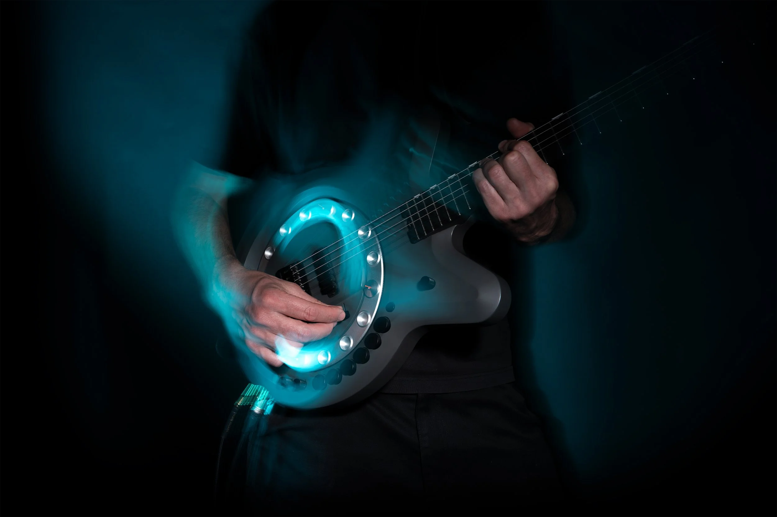 A player strumming Circle Guitar, the wheel glowing in motion