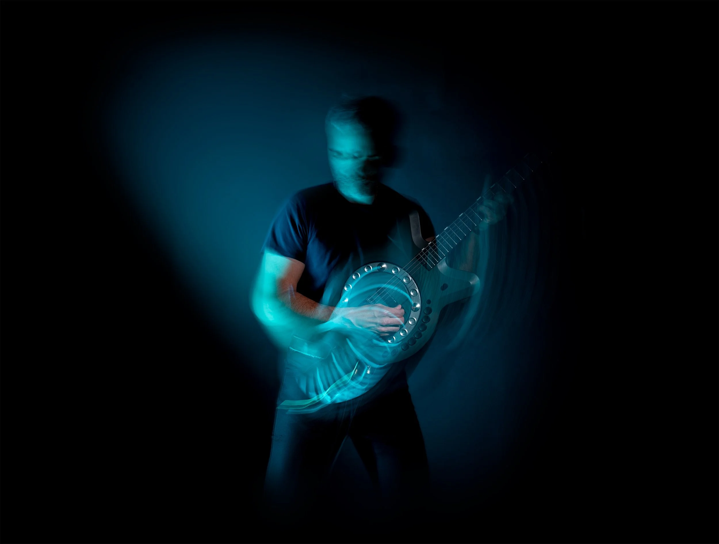 A musician playing Circle Guitar, the wheel blurred in motion