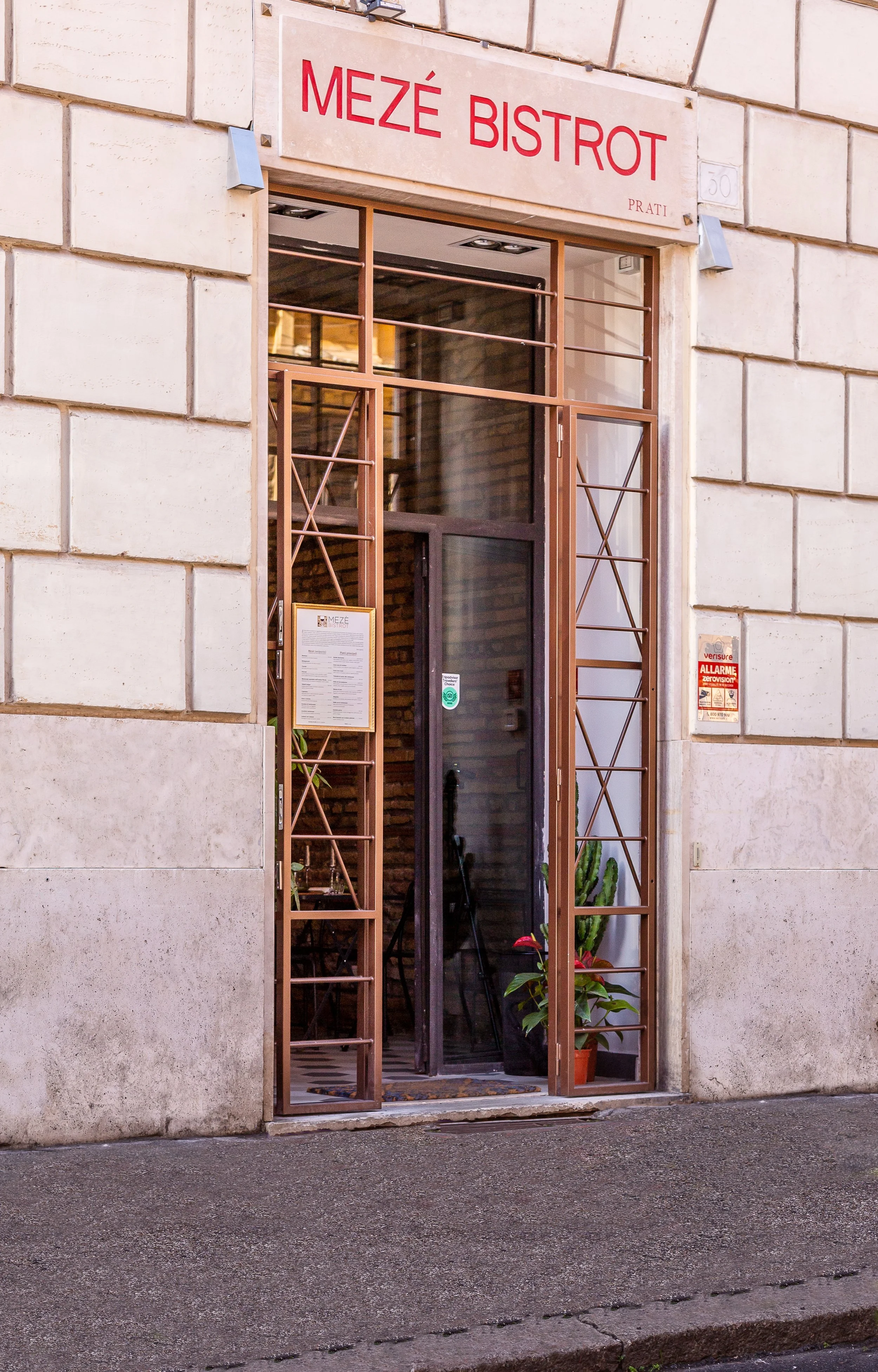 Ingresso del Meze Bistrot con porta aperta e insegna rossa.