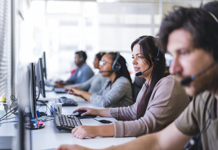 customer success technicians smiling while working in a call center.