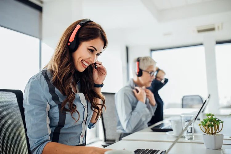 Customer service agent smiling while talking to customer in a call center