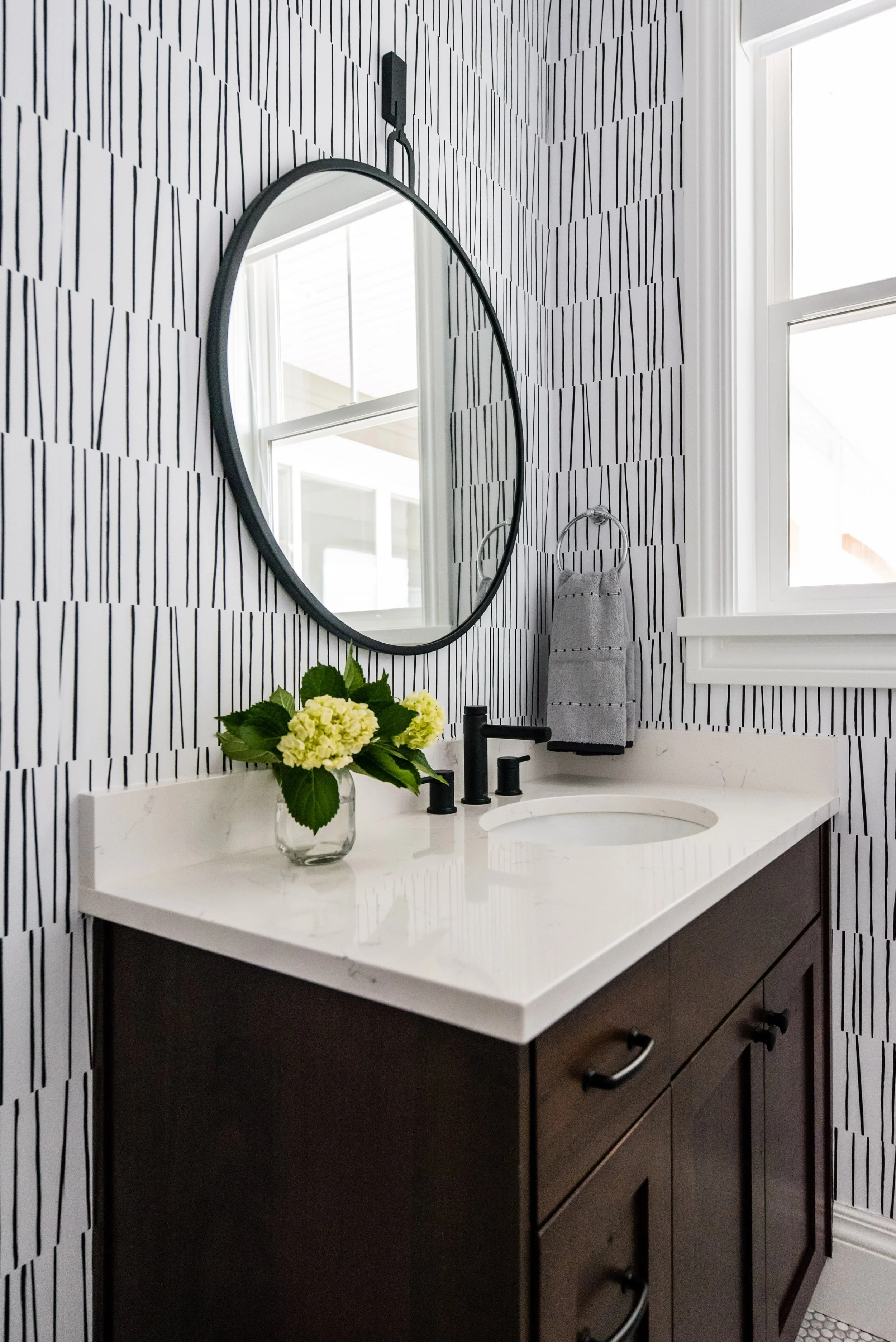 Farmhouse half bathroom with black circle mirror and wallpaper by Liz Powell Design of Northern Utah. farmhouse half bath wallpaper in bathroom #lizpowelldesign #cachevalleyinteriors #interiordesignersnothernutah #stylinghomes #northernUtahinteriors