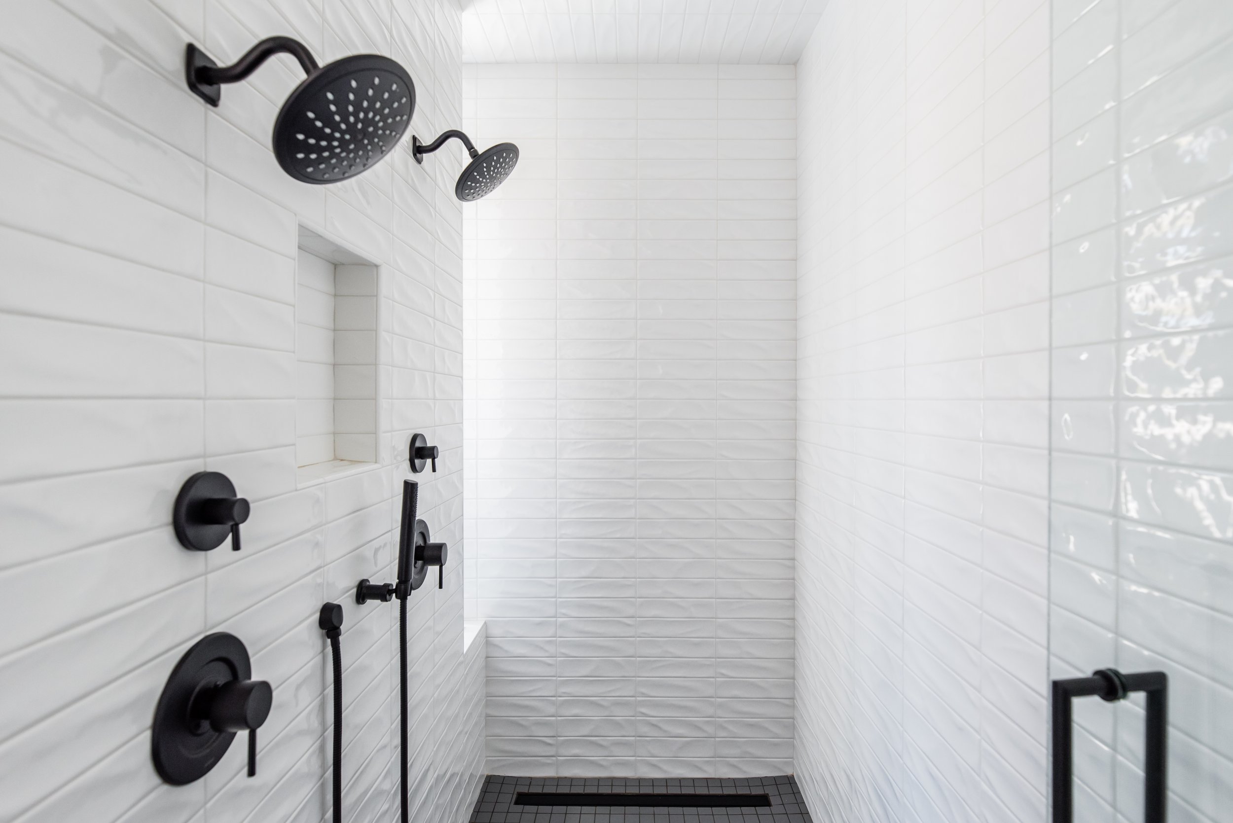  The pros and cons of glass tile in your master bathroom shower by Liz Powell Design. master bathroom two showerheads white and black bathroom #LizPowellDesign #InteriorDesignUtah #InteriorDesigner #buildingahome #tile #backsplash #dreamhome #interio