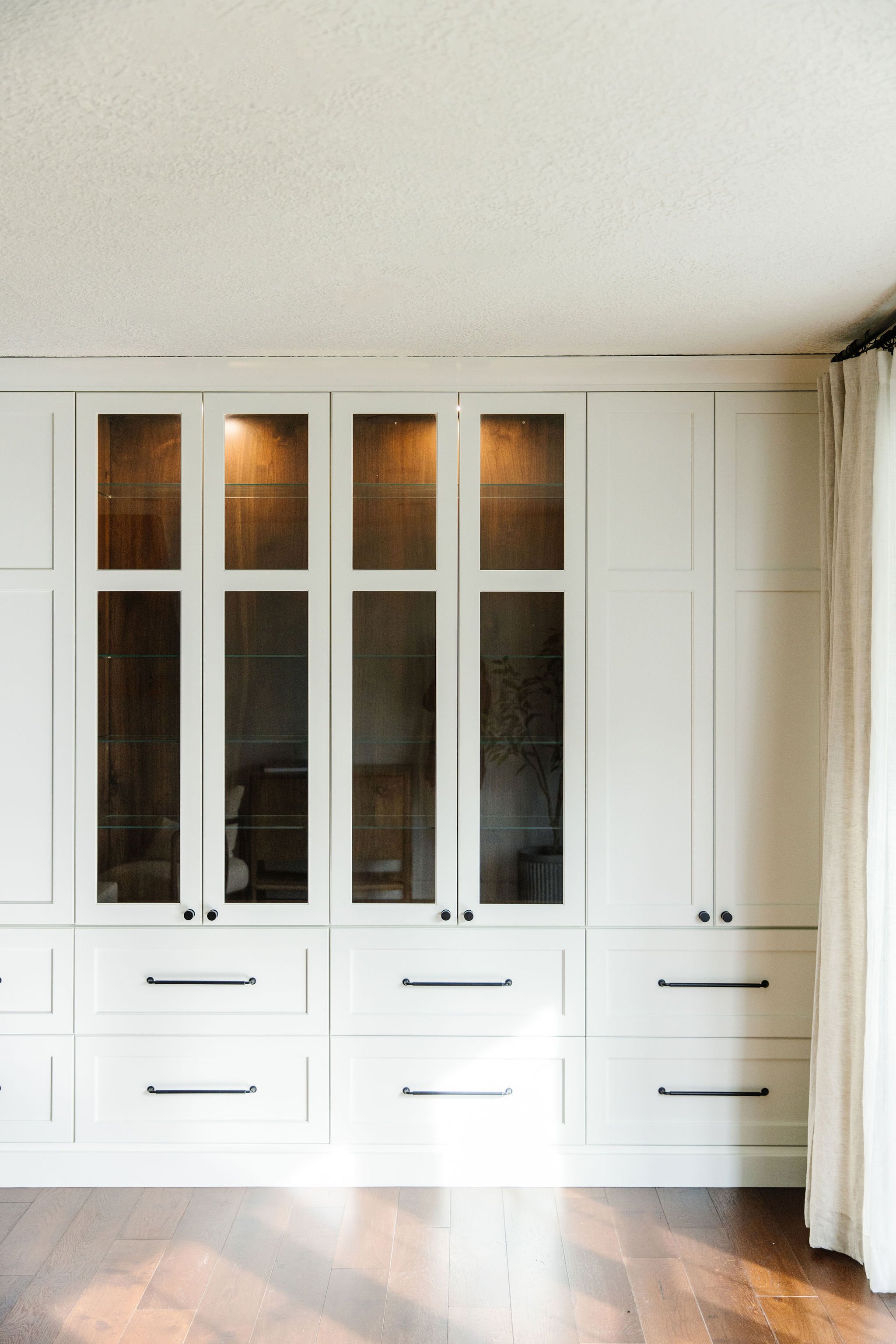  The white of these built-in cabinets is accented by the large handles and in-cabinet lighting. White build ins large drawer handles in cabinet lighting wooden floors#glasscabnietdoors #cabnietrylighting #lizpowell #whitecabniets 