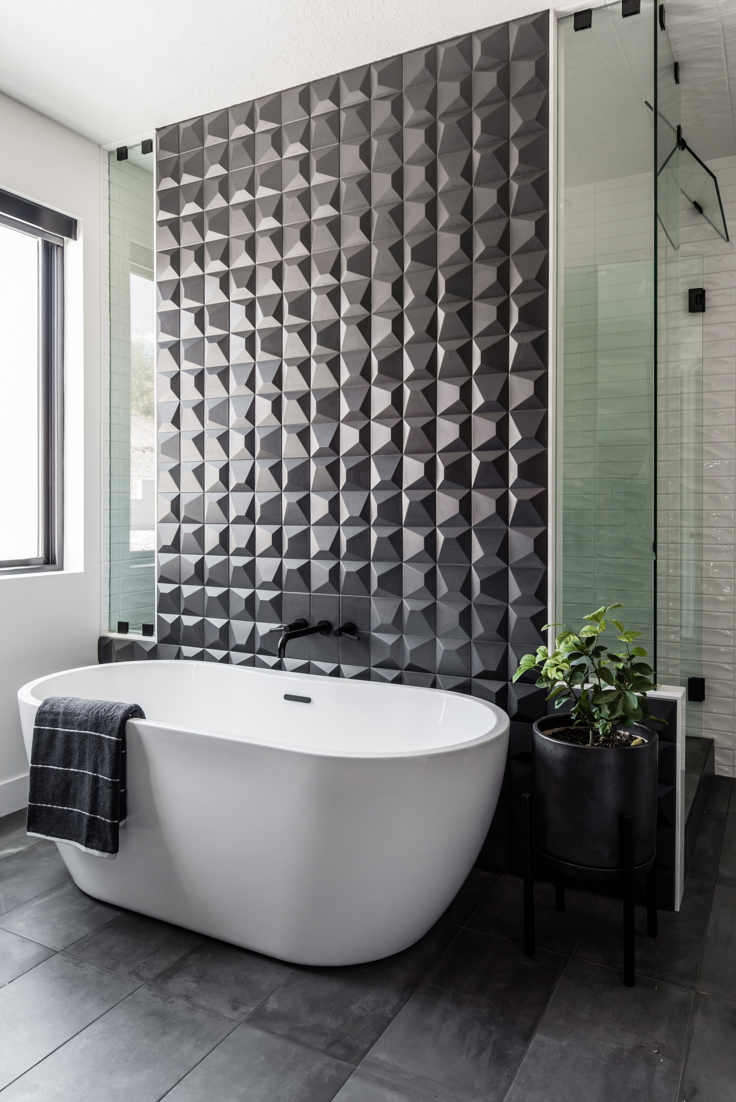  The black tiled wall behind this free-standing bathtub draws your eye to the contrast of color, making both stand out even more. Black tile bathroom freestanding bathtub Millville Utah #blacktile #blackandwhitebathroom #lizpowell 