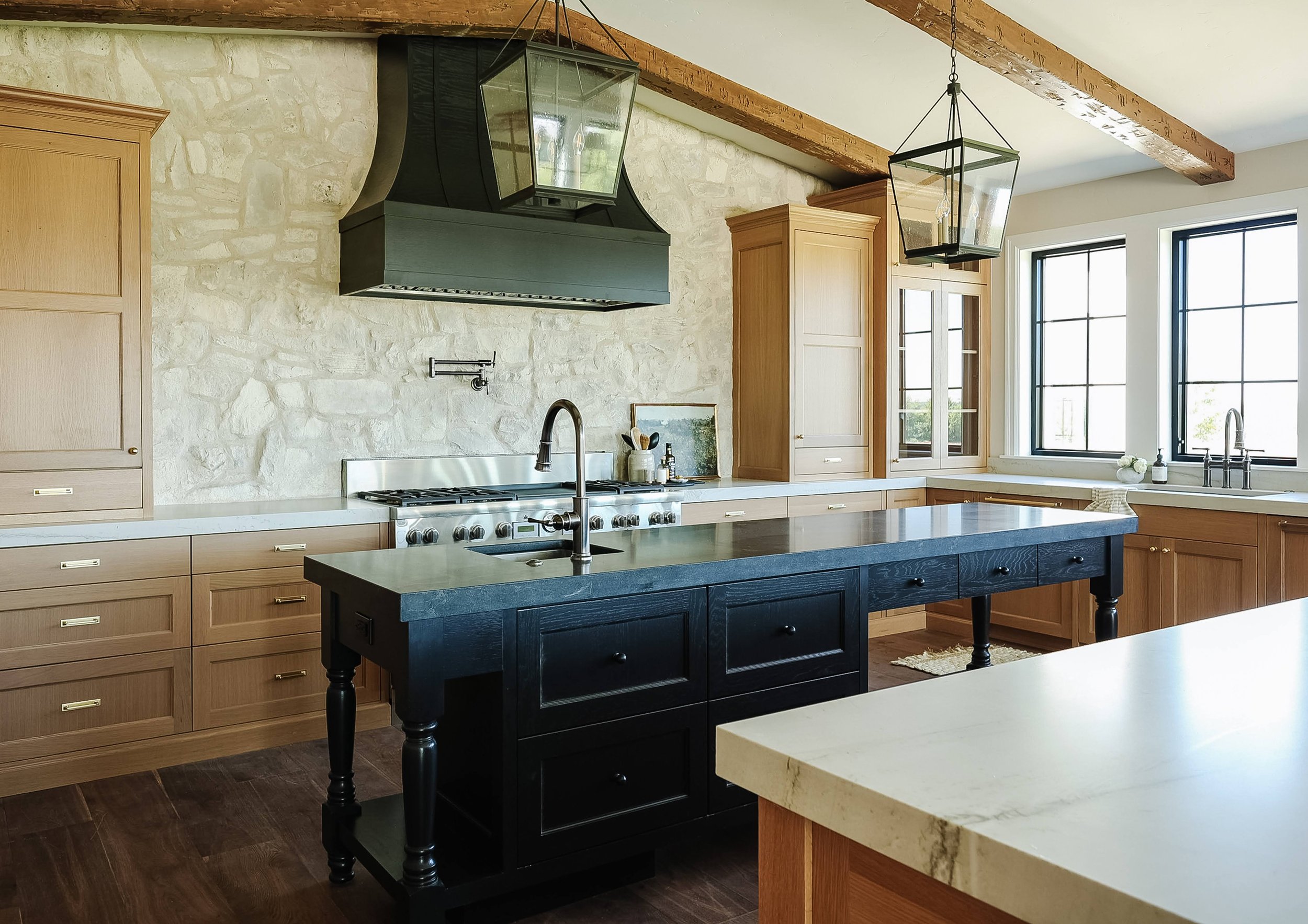  This kitchen designed by Liz Powell showcases rustic architecture with its exposed beams and stone backsplash. Exposed beams lantern pendant lights Logan Utah rustic kitchen #exposedbeams #rustickitchen #pendantlights #stonebacksplash 