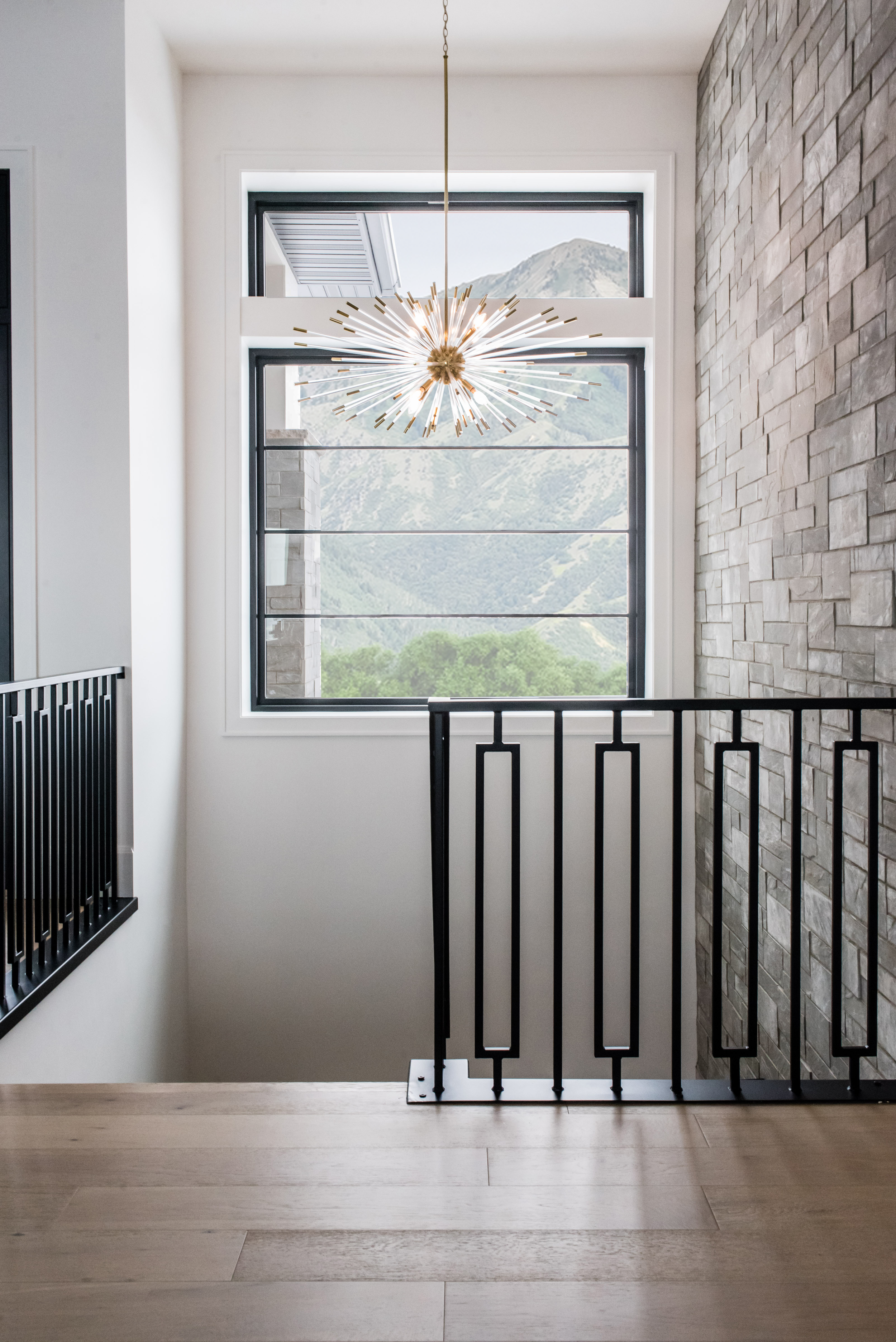 Unique chandelier hangs over the staircase in a Liz Powell Design home. Large window lets in a lot of light. #LizPowellDesign #InteriorDesignUtah #CacheValleyNewBuilds #CacheValleyInteriors #FullServiceDesign #CustomDesign #DesignConsultation #Virtua