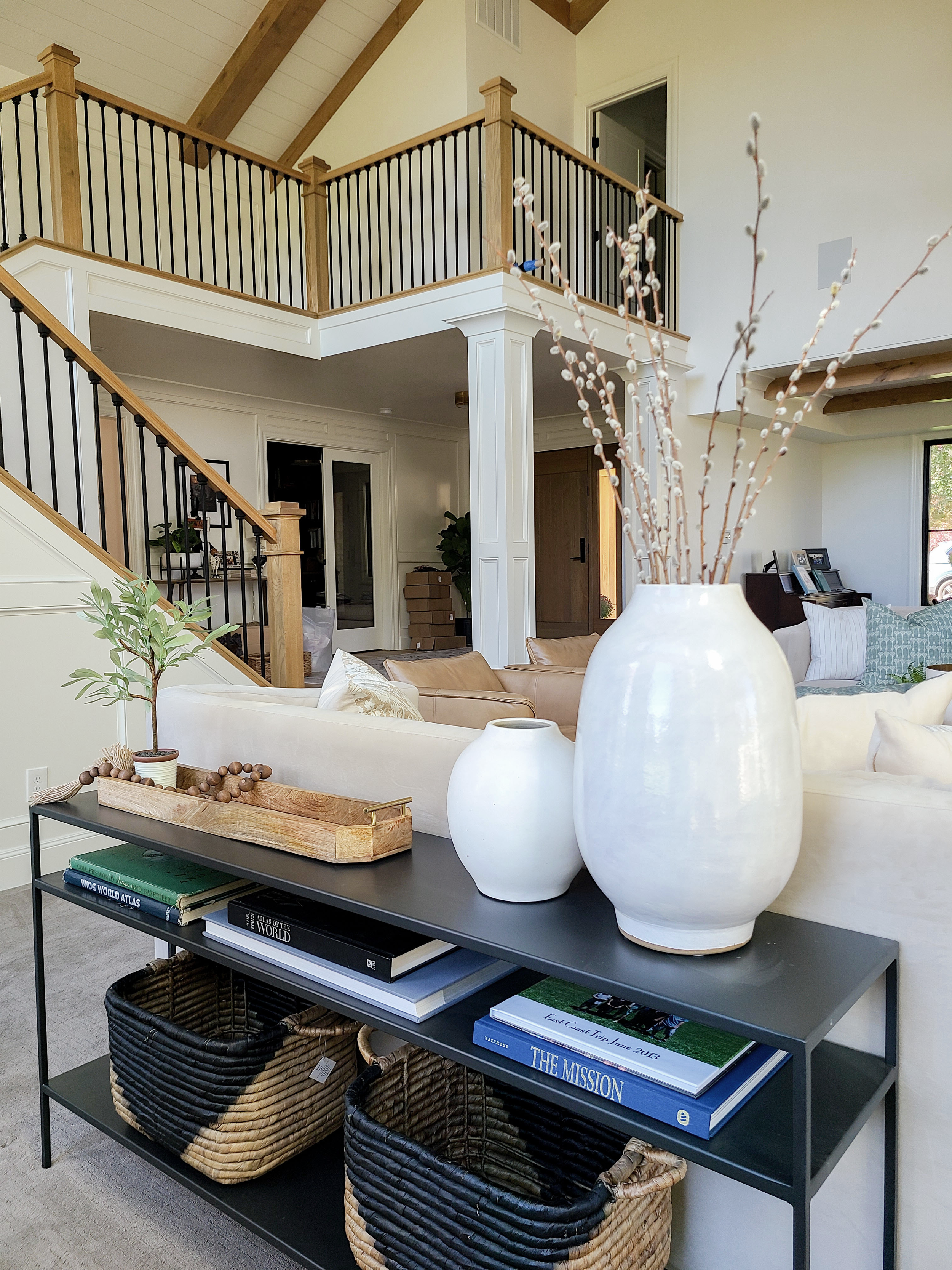 Open living room with black metal stair railing designed by Liz Powell Designs of Logan, UT. metal staircase light wood and metal stairs #lizpowelldesign #cachevalleyinteriors #interiordesignersnothernutah #stylinghomes #northernUtahinteriors