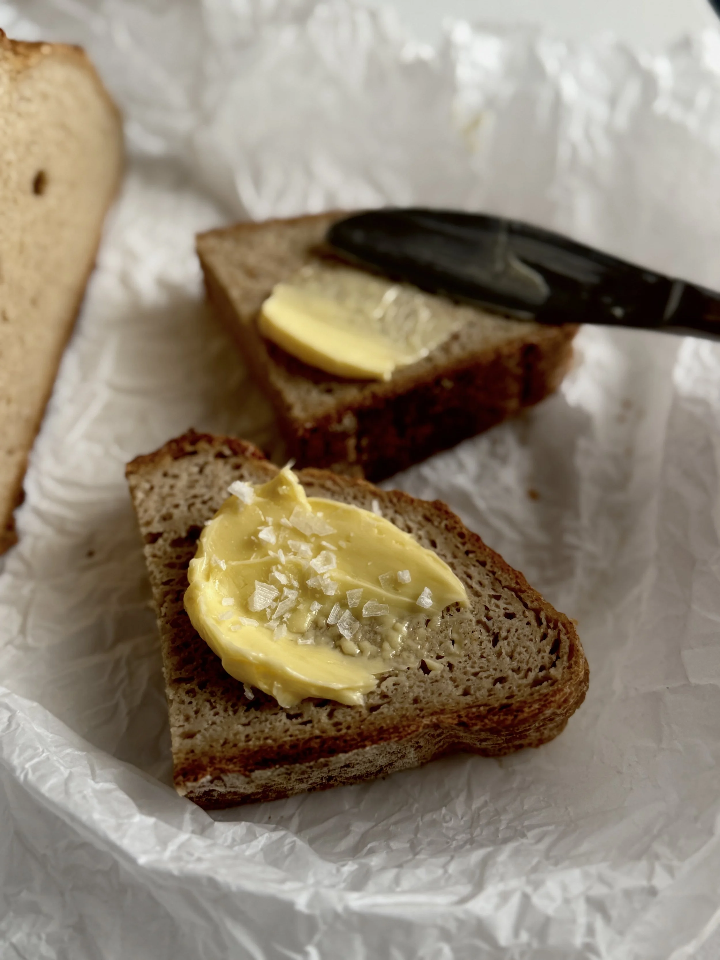 Gluten Free Sourdough slice slathered in butter and flakey sea salt