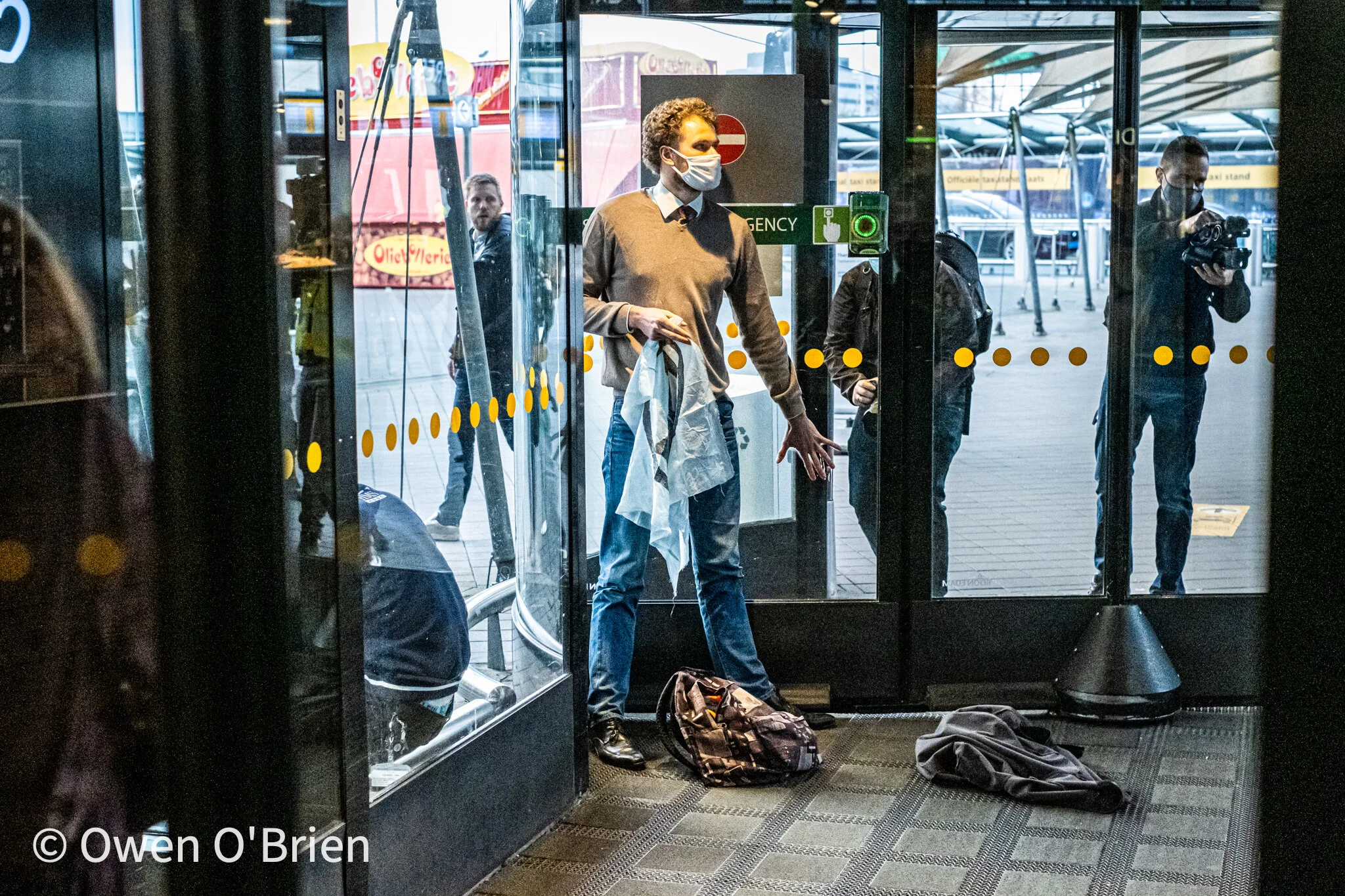 De actievoerders hebben zich vast gelijmd aan de glazen wanden van de deuren en blokkeren hiermee de ingang naar de vertrekhallen (december 2020).