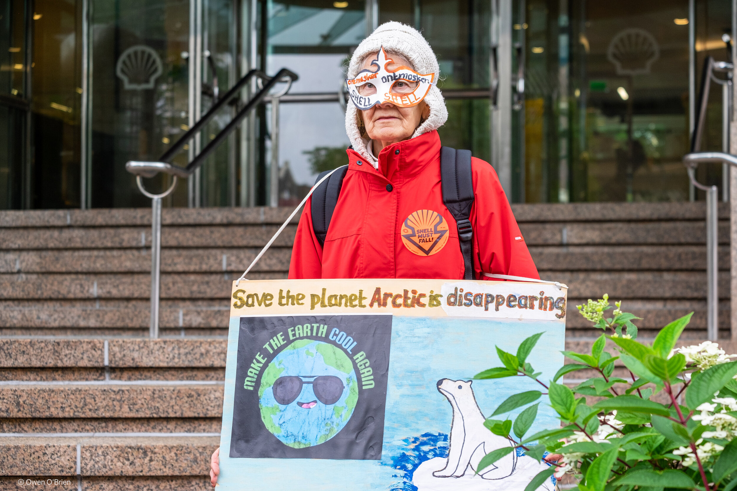 Een demonstrant van Extinction Rebellion voor het hoofdkantoor van Shell in Den Haag (juli 2021).