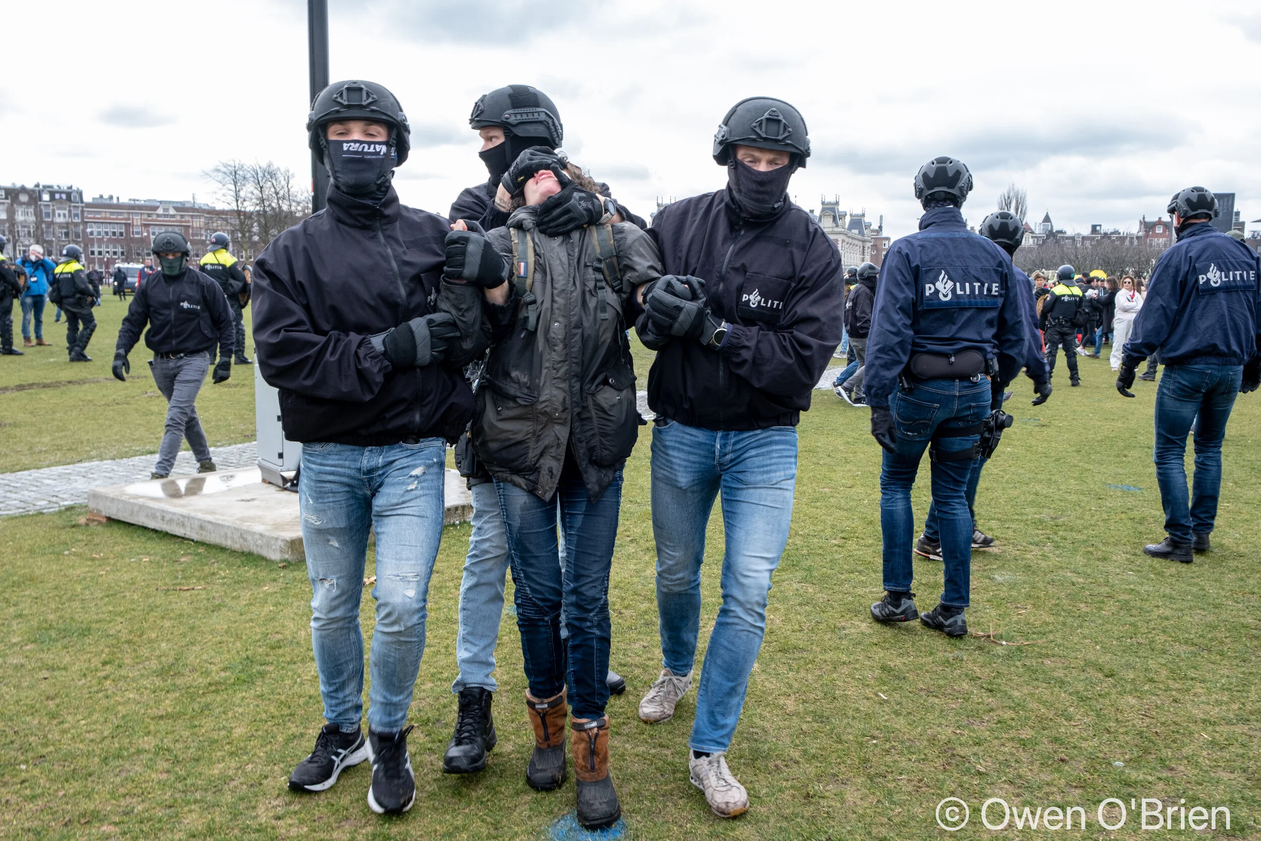 Een demonstrant wordt aangehouden op het Museumplein in Amsterdam (20-03-2021).