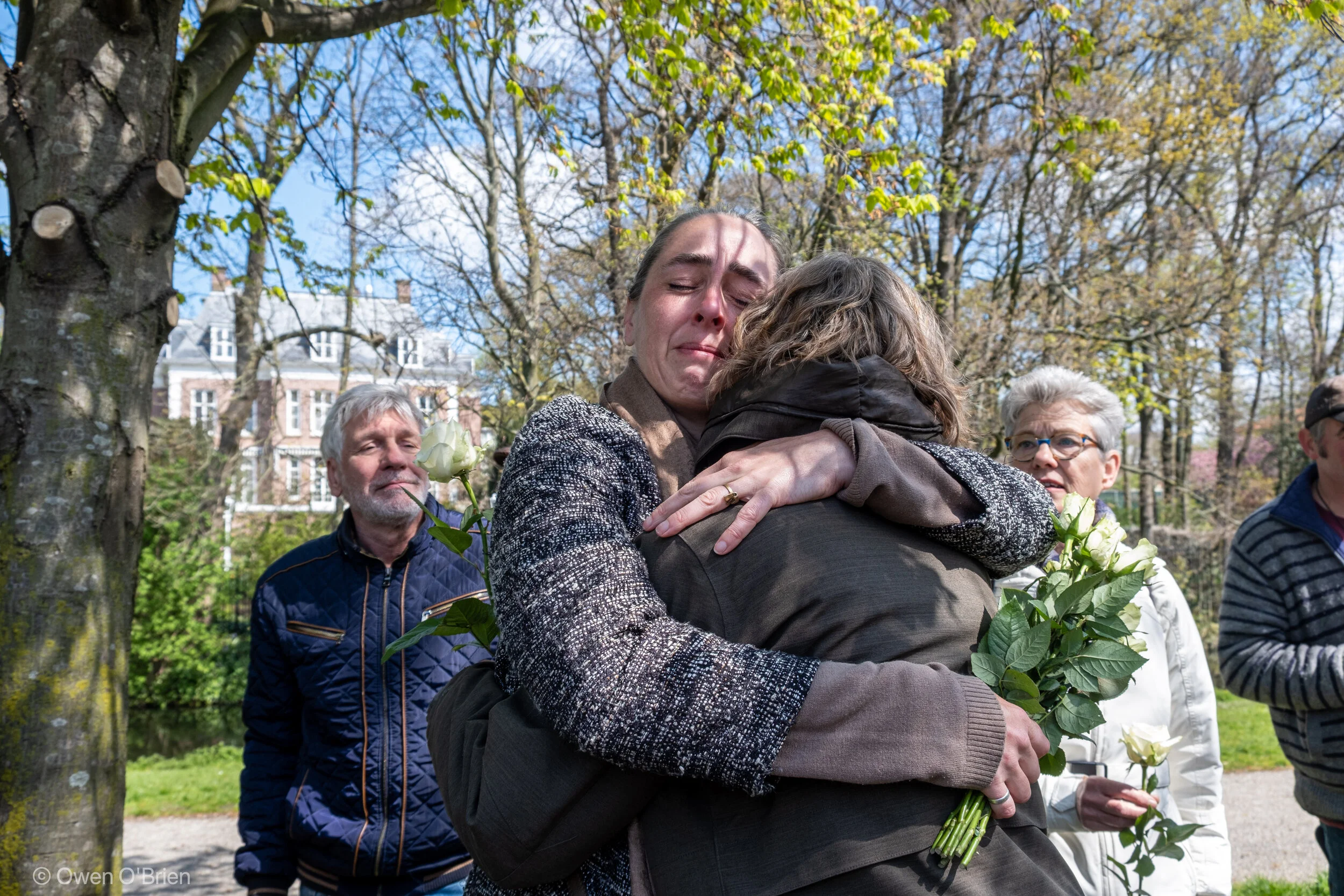 Demonstranten van VirusWaarheid zoeken troost bij elkaar voordat er witte rozen worden neergelegd bij de Duitse ambassade (mei 2021).