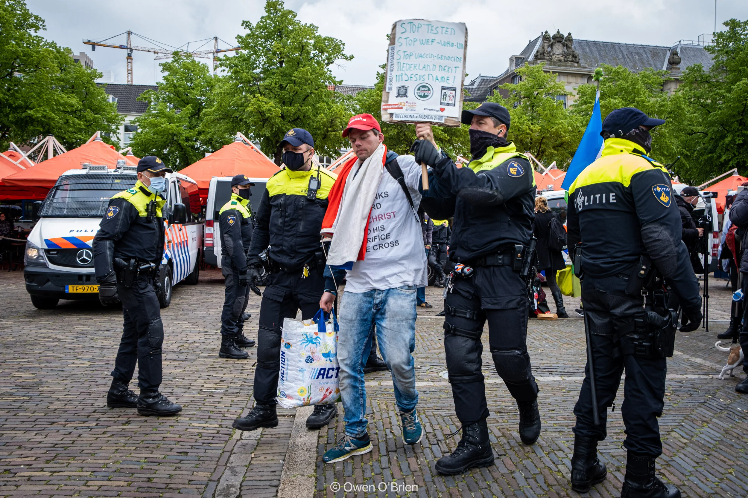 Een demonstrant wordt opgepakt op het Plein in Den Haag nadat hij vorderingen van de politie weigert op te volgen (mei 2021). 