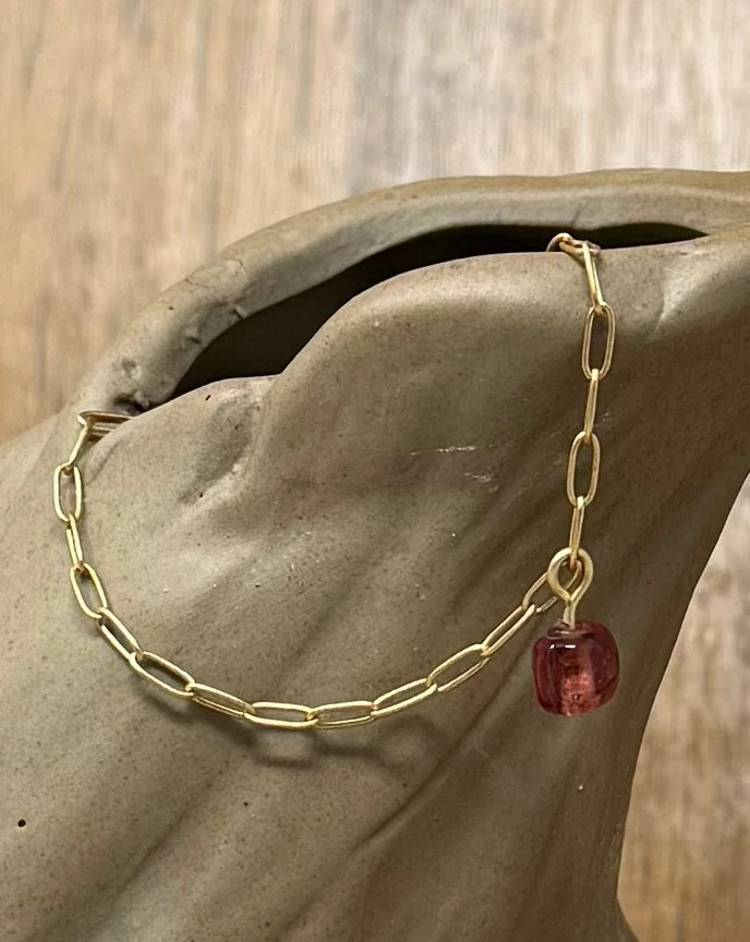 Small paperclip with dark pink glass