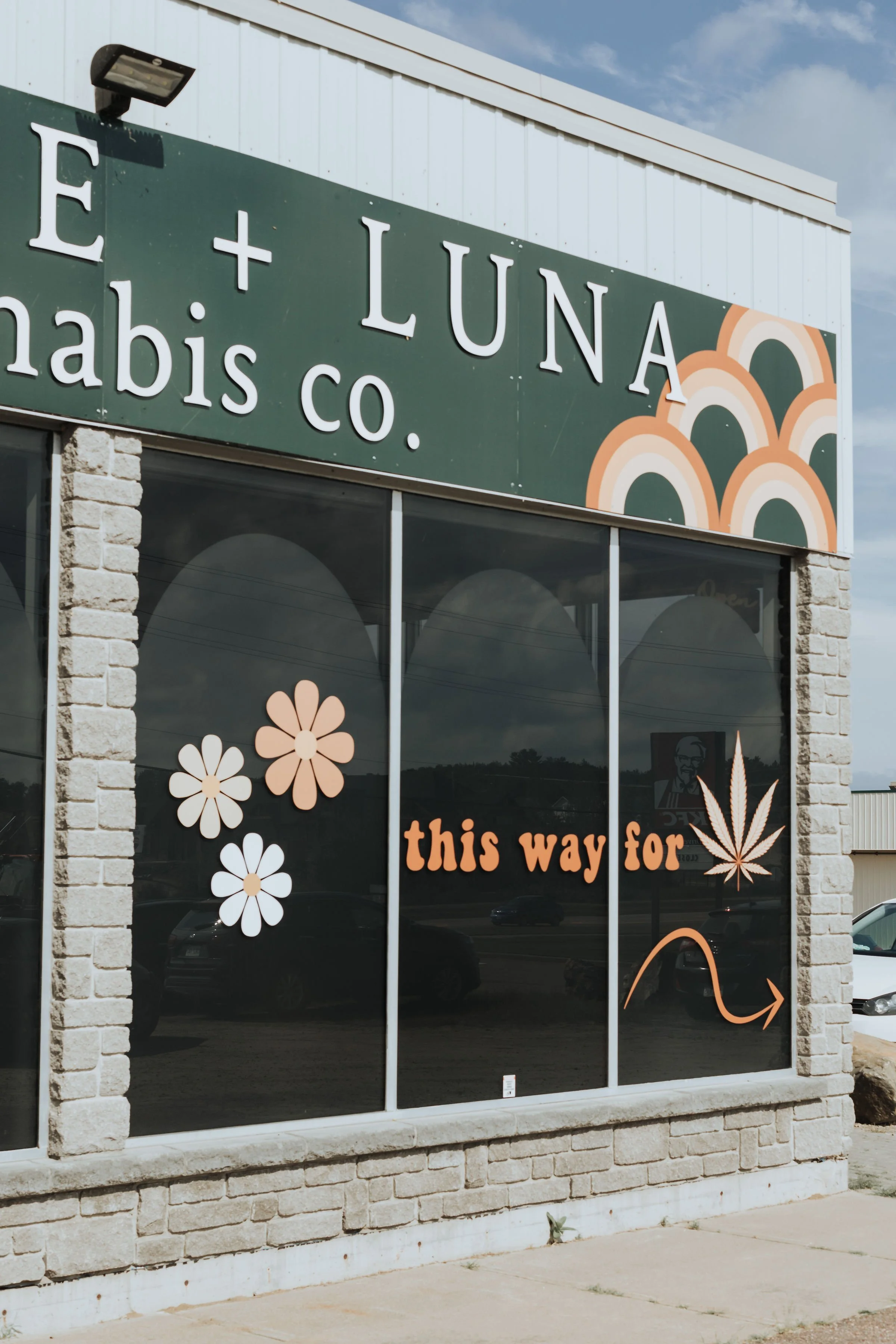 Exterior shot of Prairie and Luna, spotlighting the sign that reads “This Way for Cannabis.”