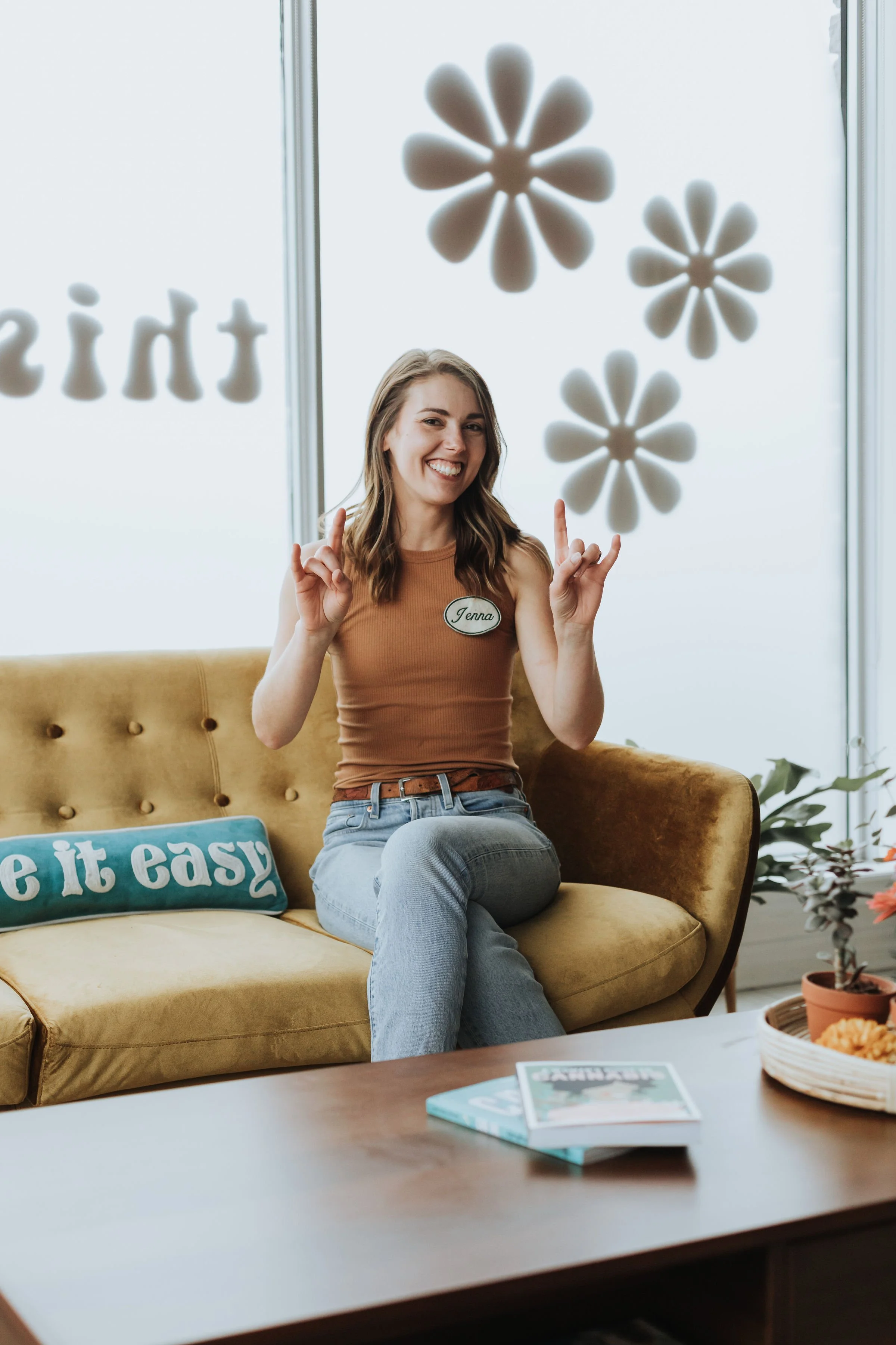 Jenna, co-owner of Prairie and Luna, lounging in the store’s menu corner and throwing her signature rock-on hand sign.