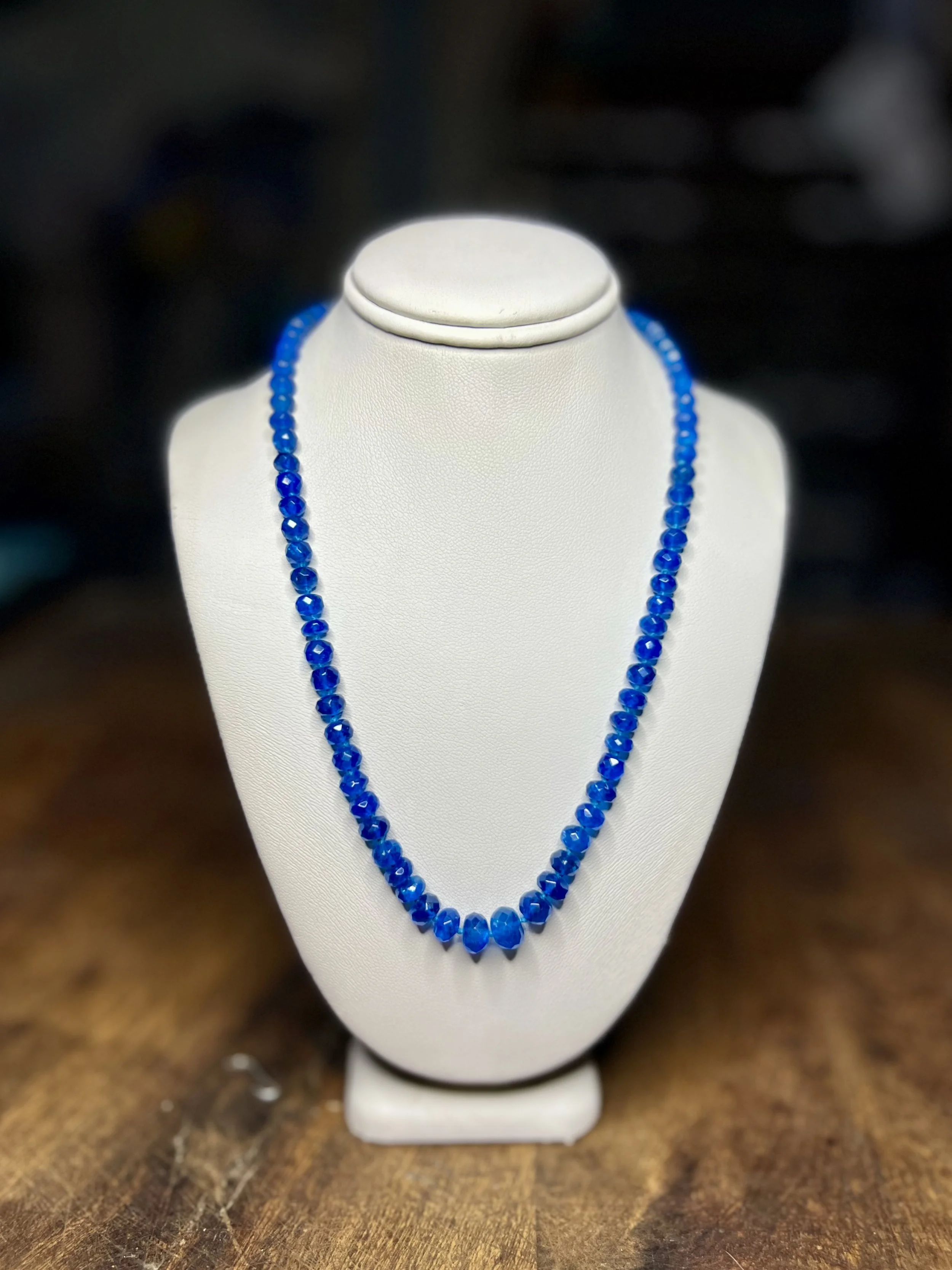 Blue Apatite necklace displayed on a white jewelry stand.
