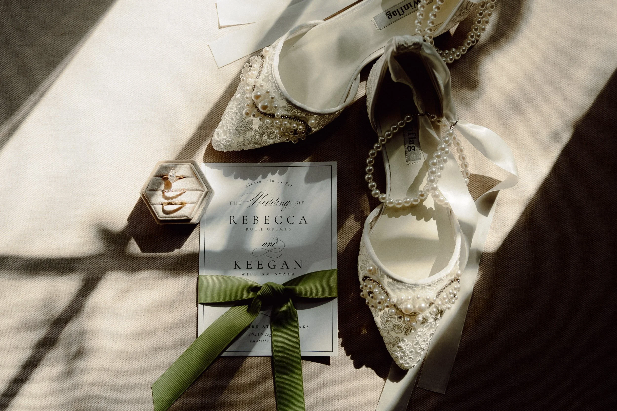 wedding details of invites, wedding rings, and bride's shoes at The Barn at Southern Oaks in Umatilla, FL