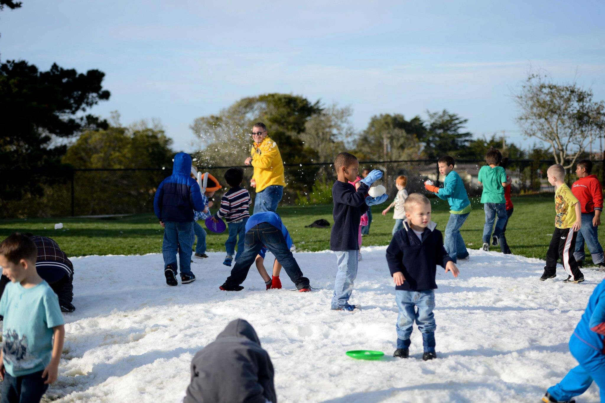 Residents and their children engage in a lighthearted snowball fight. 
