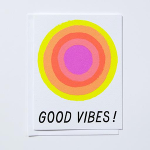 Good Vibes Greeting Card. Card Has Stylized Sun In HOt Pink, Orange And Yellow Centered Above hand Drawn Type In Black That Reads “Good Vibes!”