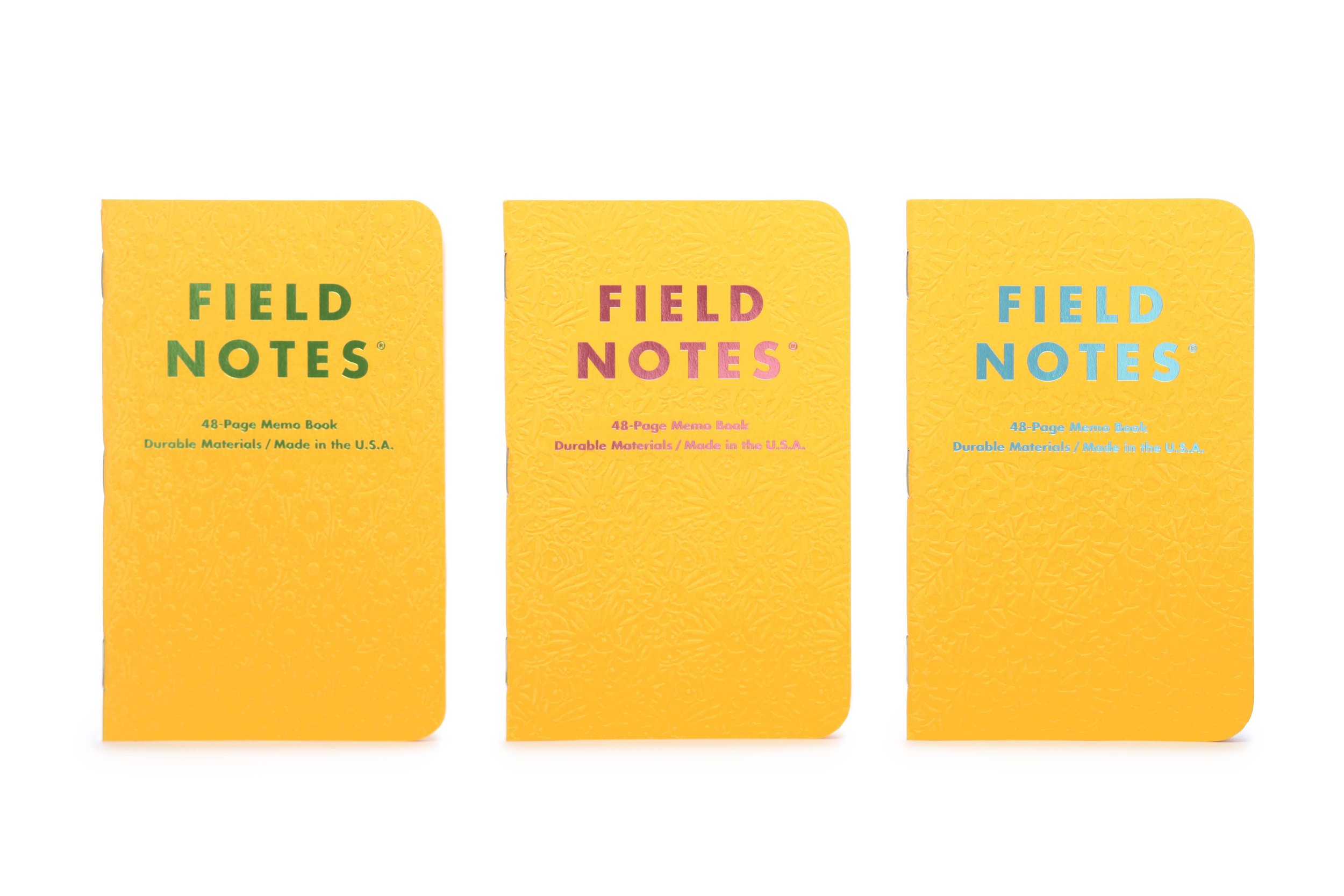 Image Of Three Deep Yellow Field Notes Graph Paper Notebooks With Embossed Flower Covers And Metallic Futura Type Stamped Covers.