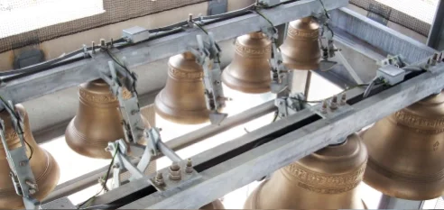 Sistema de automatización de campanas instalado en un bastidor estructural que controla varias campanas de bronce de una iglesia dentro de un campanario