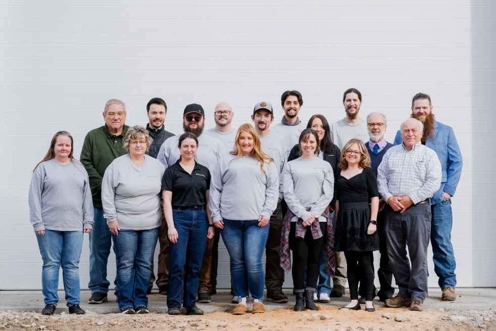 Un grupo de empleados e ingenieros posando frente a las instalaciones de la empresa, en representación de las personas que están detrás de los sistemas de campanas y carillones de las iglesias