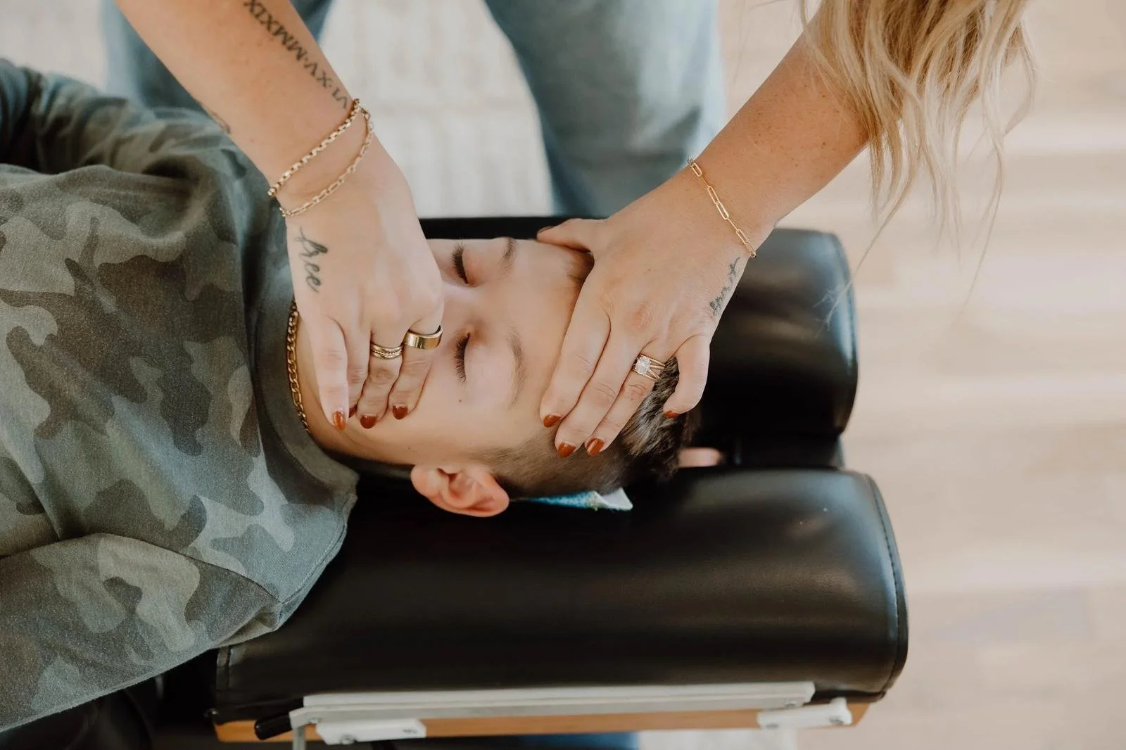 Gentle nasal adjustment on young child lying on chiropractic table, close-up hands — pediatric chiropractor in Tulsa, Oklahoma