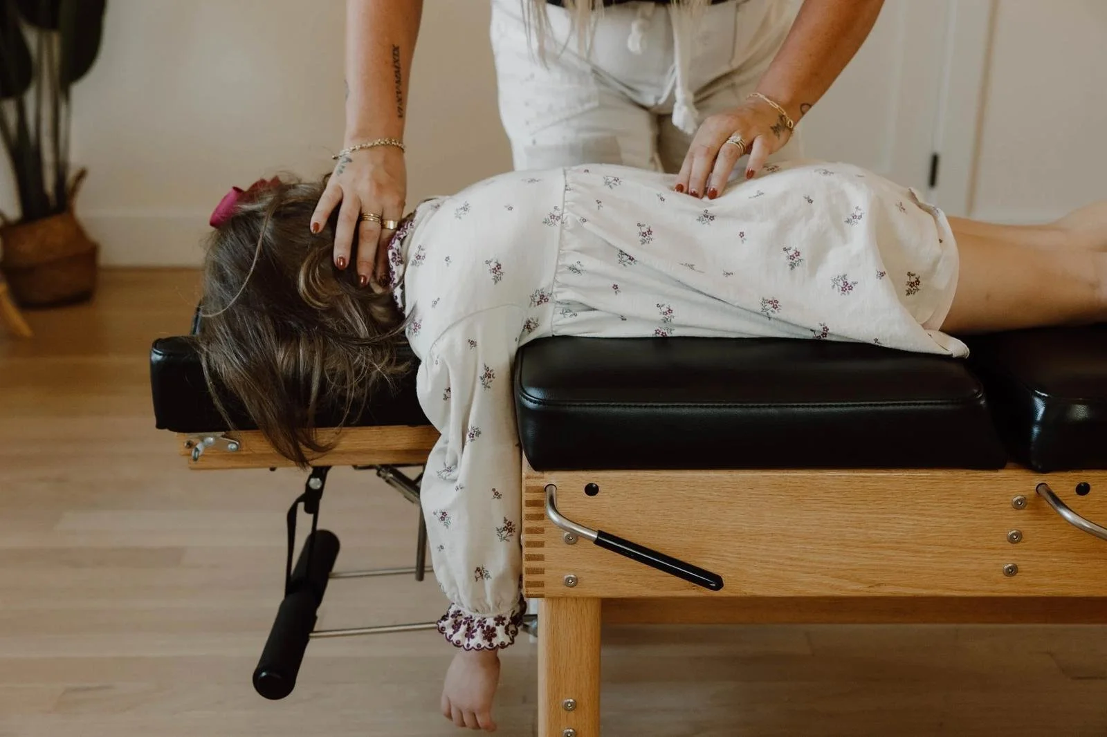 Dr. Lacey examining baby lying face-down on chiropractic table for gentle assessment — infant chiropractic care at Free Spirit Chiropractic in Tulsa